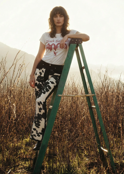 Rodeo bell bottom jeans in black cow print, high-rise waist with faux cowhide inserts, 32-inch inseam, made in USA