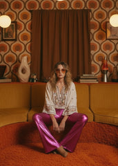 Women wearing pink metallic flare pants with elasticized waist – side view, 70s glam style