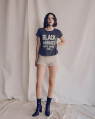 Person wearing a 'Black Sabbath' t-shirt with white text against a plain background