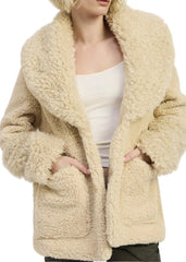 Woman wearing a beige sherpa coat on a white background