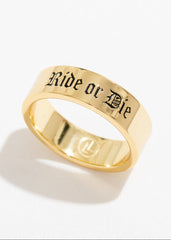 Gold ring with 'Ride or Die' engraving on a white background