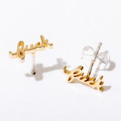 Gold 'luck' earrings on a white background