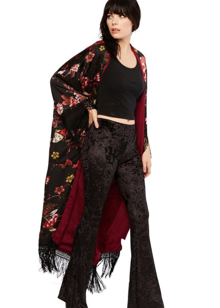 Woman wearing a black floral kimono with red accents boho flare pants velvet rockstar style