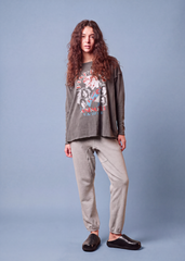 Full-length front view of a model wearing the charcoal Pink Floyd Animals long sleeve tee with gray pants and black clogs.