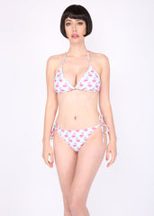 Woman wearing a pink bikini with floral pattern on a white background