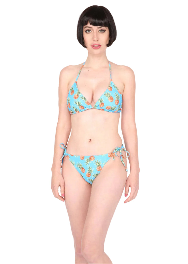 Woman wearing a blue bikini with pineapple pattern on a white background