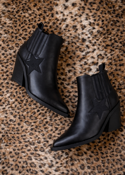 Black ankle boots on a leopard print surface