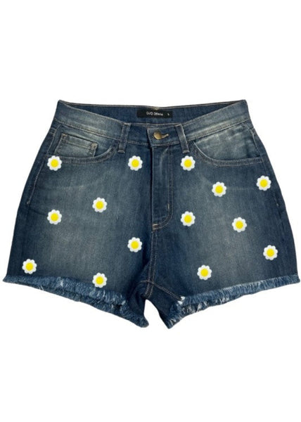 High waisted blue denim shorts with white and yellow daisy embroidered patches and raw hem detail