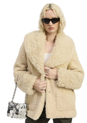 Woman wearing a beige teddy coat with sunglasses and a handbag on a white background