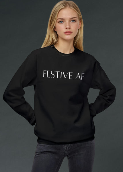 Woman wearing a black alternative Christmas sweater with 'FESTIVE AF' text on a dark background