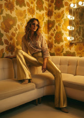 Gold metallic bell bottoms styled with silky halter top and strappy heels for a night out