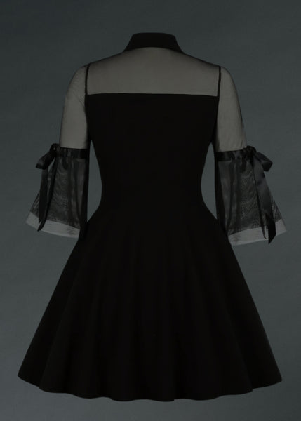 Black velvet goth mini dress with sheer sleeves on a gray background