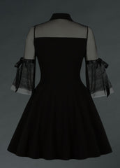 Black velvet goth mini dress with sheer sleeves on a gray background