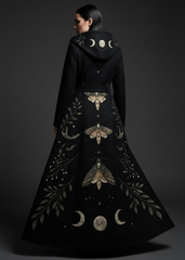 Back close-up of black celestial gothic coat with skull moth, crescent moon phases, and botanical print, women's gothic winter outerwear

