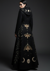 Back view of women's black gothic maxi coat with celestial moth and moon phase print, hooded belted style
