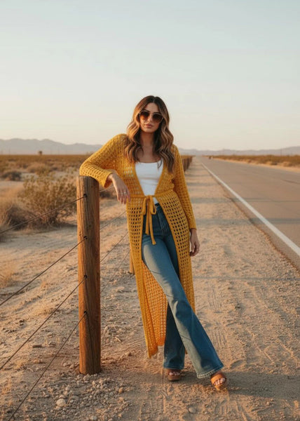Woman wearing yellow crochet maxi kimono over swimsuit at beach, boho resort wear
