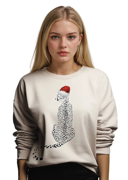 Woman wearing a beige sweater with a cheetah wearing a Santa hat design on a plain background