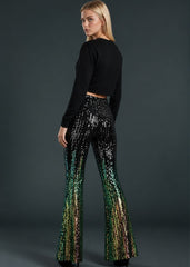 Model wearing black and green sequin bell bottom flare pants with flared leg detail