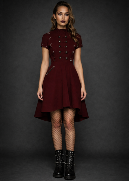 Burgundy gothic military style dress with metal button details worn with black fishnet tights and studded combat boots on a dark gray studio background
