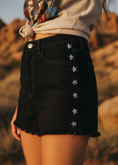 Close-up of silver star studs on denim shorts hip to knee – women's embellished festival jean shorts