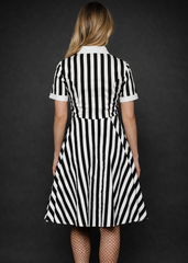 Women's black and white striped gothic A-line dress with collared neckline and button front, alternative rock fashion outfit with fishnet tights