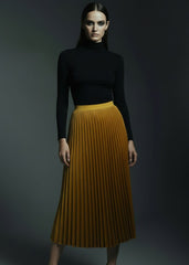 Golden mustard velvet pleated midi skirt with wide yellow elastic waistband on model
